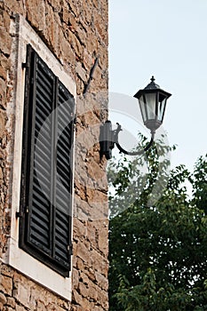 Old stonewalled house with window and lamp