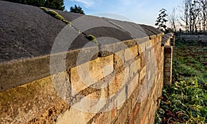 Old stonework boundary wall seen at an old church yard.