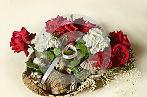 Straw basket with a bouquet of red roses, white hydrangeas and eucalyptus branches with sea shells