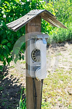 Old street disk wired phone. The village telephone booth.