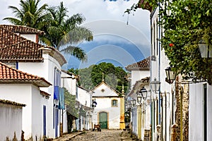 Old street with its lanterns, colonial style houses, cobblestone pavement and historic church