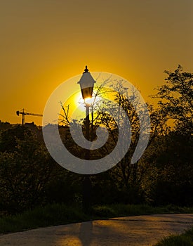 An old street lamp over sunset sky