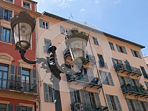 Old street lamp and view of the colorful houses Nice Cote d`Azur in France of French riviera tourist destination with beach on