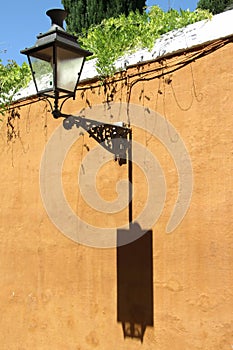 Old street lamp on the wall in the center of Seville photo