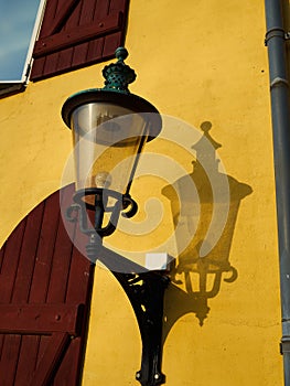 Old street light lamp lantern on a yellow wall in Denmark