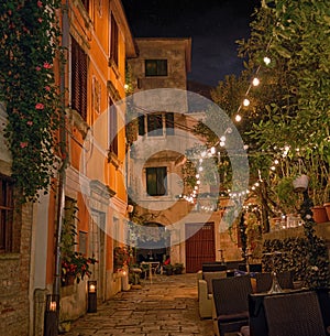 Old street in Porec town illuminated by lamps at the evening