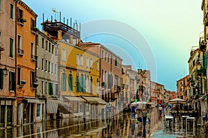 Old street with small colorful houses in the rain. Garibaldi street. Venice, Italy