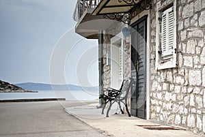 Old street of stone houses with bench by the sea