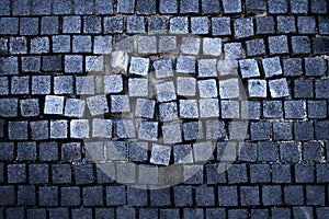 Old street surface: unsettled cobbles, tiles on pothole road color photo for backgrounds.