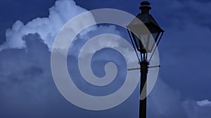 Old streetlamp silhouette against dark clouds