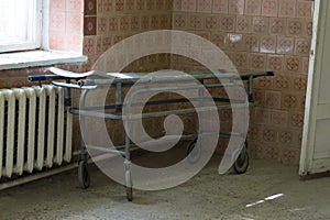Old stretcher gurney bed in the hospital hallway. A horrible old hospital or morgue