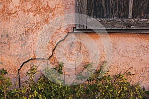 Old stucco house cabin with cracked wall crack