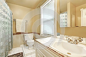 Old style bathroom interior with white tile floor