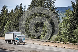 Old style cab over big rig semi truck transporting dusty cargo in covered bulk semi trailer running on the interstate highway road