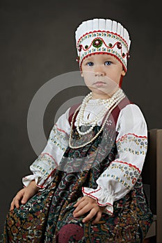 Old style portrait of the little girl in the traditional russian shirt, sarafan and kokoshnik photo