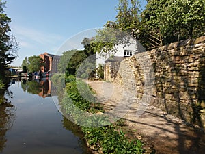 Old style stone wall on canal side towpath,