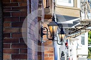 Old style street lamp and old brown brick wall