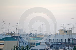 Old-style TV and radio antennas on house rooftops