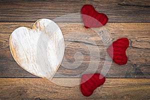 Retro classic Valentine`s Day cad, large white painted wooden hart, isolated, 3 red cuddle harts, on vintage oak panels - top view
