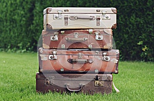 Old stylish brown suitcases on the garden