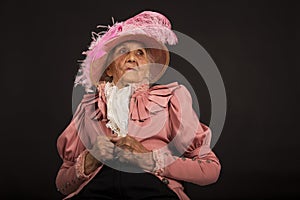 Old stylish lady in mauve jacket and a hat