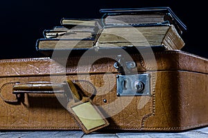 Old stylish suitcase. Old books in a suitcase. Suitcase on a wooden table.