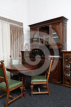 Old, stylish, vintage furniture, wardrobe, mirror, brown chairs in natupal wood interior