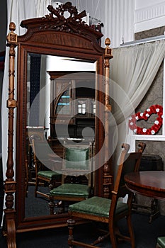 Old, stylish, vintage furniture, wardrobe, mirror, brown chairs in natupal wood interior