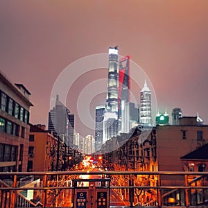 Old subborbs vs modern skyscrappers of Shanghai city in China night view photo