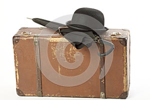 Old suitcase, bowler hat and umbrella