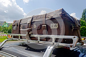 Old suitcase on the car roof rack