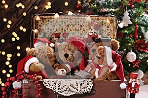Old suitcase full of teddy bears in Santa caps