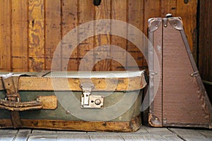 An old suitcase of green and yellow leather put on the ground photo