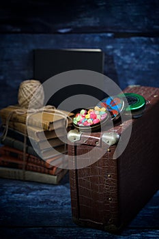 Old suitcase with sweets and books in the dark