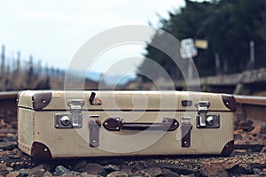 Old suitcase at the train station with retro effect