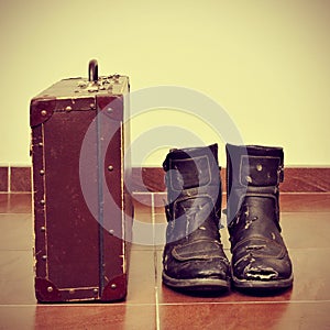Old suitcase and worn boots