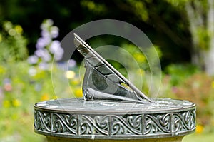 Old sun clock in a flowering garden