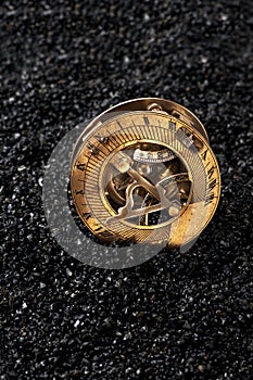 Old sundial with compass on black background