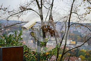 Old surveillance camera and solar light in shrubbery