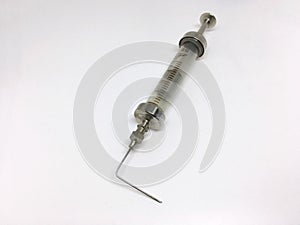 old syringe with a curved needle, the syringe is made of glass and metal in the Russian Federation. isolated on white