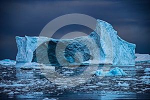 Old tabular iceberg with zodiac and expedition group, Antarctica photo