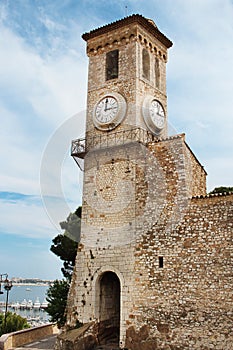 Old tall clock tower on blue sky background with sea view