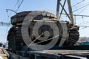 Old tank with artisanal reactive armor on a railway flatcar