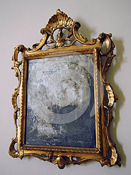 old tarnished gold framed mirror with ornate baroque details