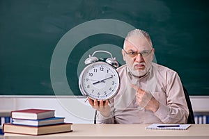 Old male teacher in time management concept