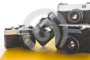 Old Technology Concept. Vintage Film Cameras On Yellow Surface, Front View