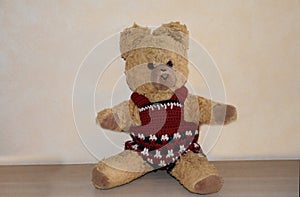 Old teddy bear with  handmade red trousers