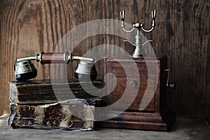 Old telephone and retro book on a wood