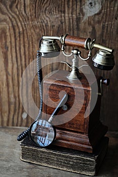 Old telephone and retro book on a wood