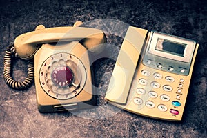 An old telephone with rotary dial and a landline on a grunge background